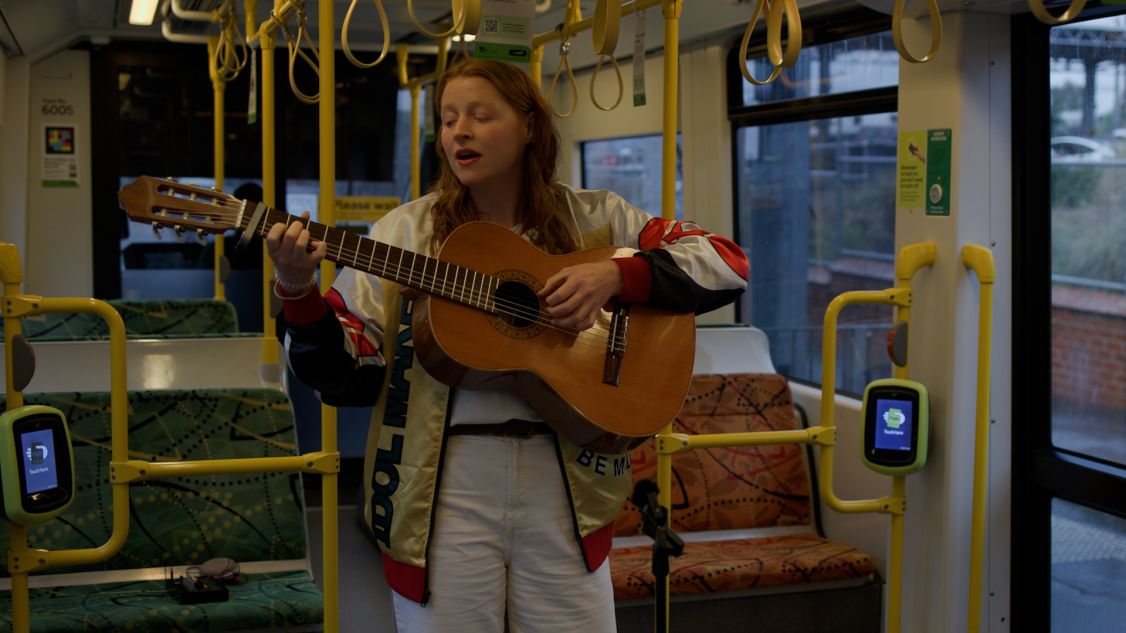 woman playing guitar while sitting