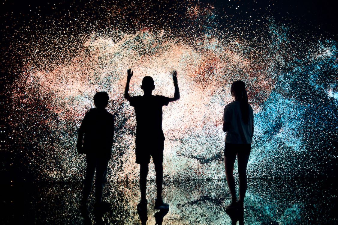 silhouette of three kids standing in front of a starry wall