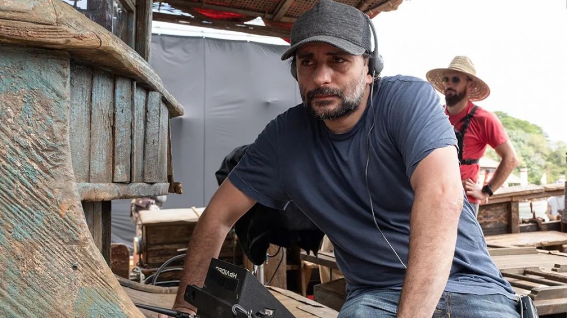 man standing behind a film camera