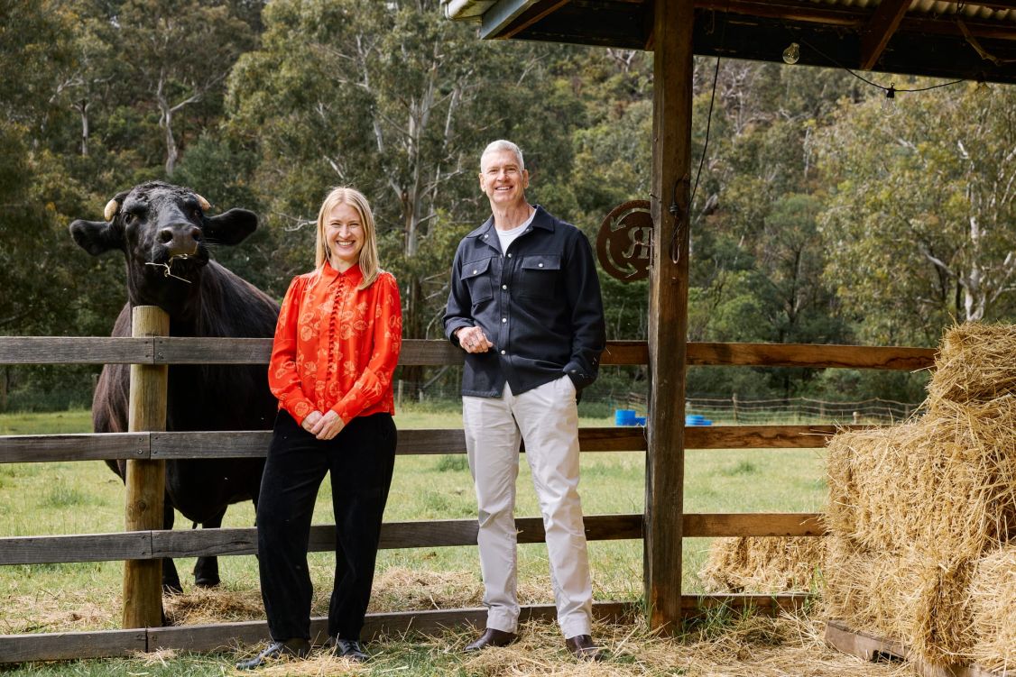 man and woman posing with a horse