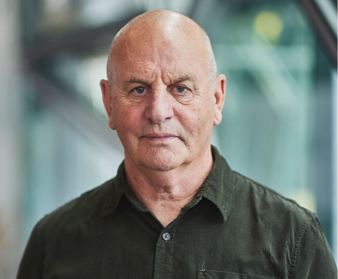 Man in dark shirt smiling at camera